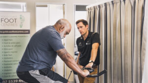 Dr. Adam Walker discussing knee education with a patient to improve understanding of knee OA at Gold Coast Knee Group